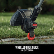 Photo of Craftsman CMCST915C1 string trimmer close-up with red wheeled edge guide on grass and stone.